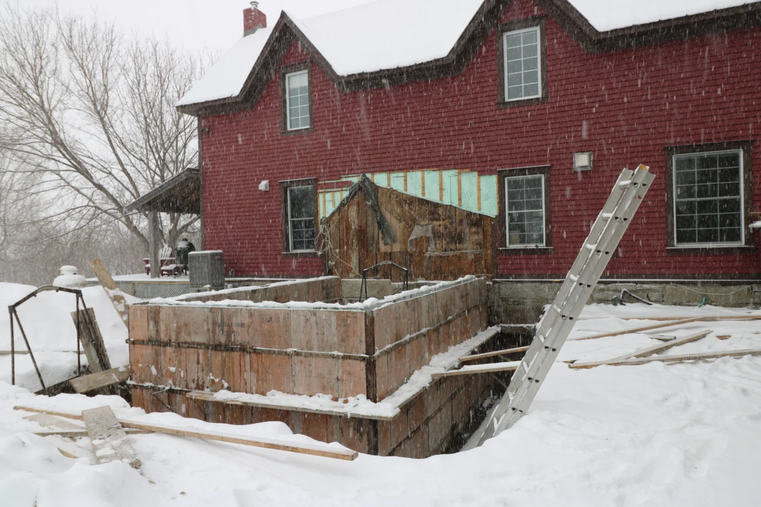 Home addition under construction beside a brick house