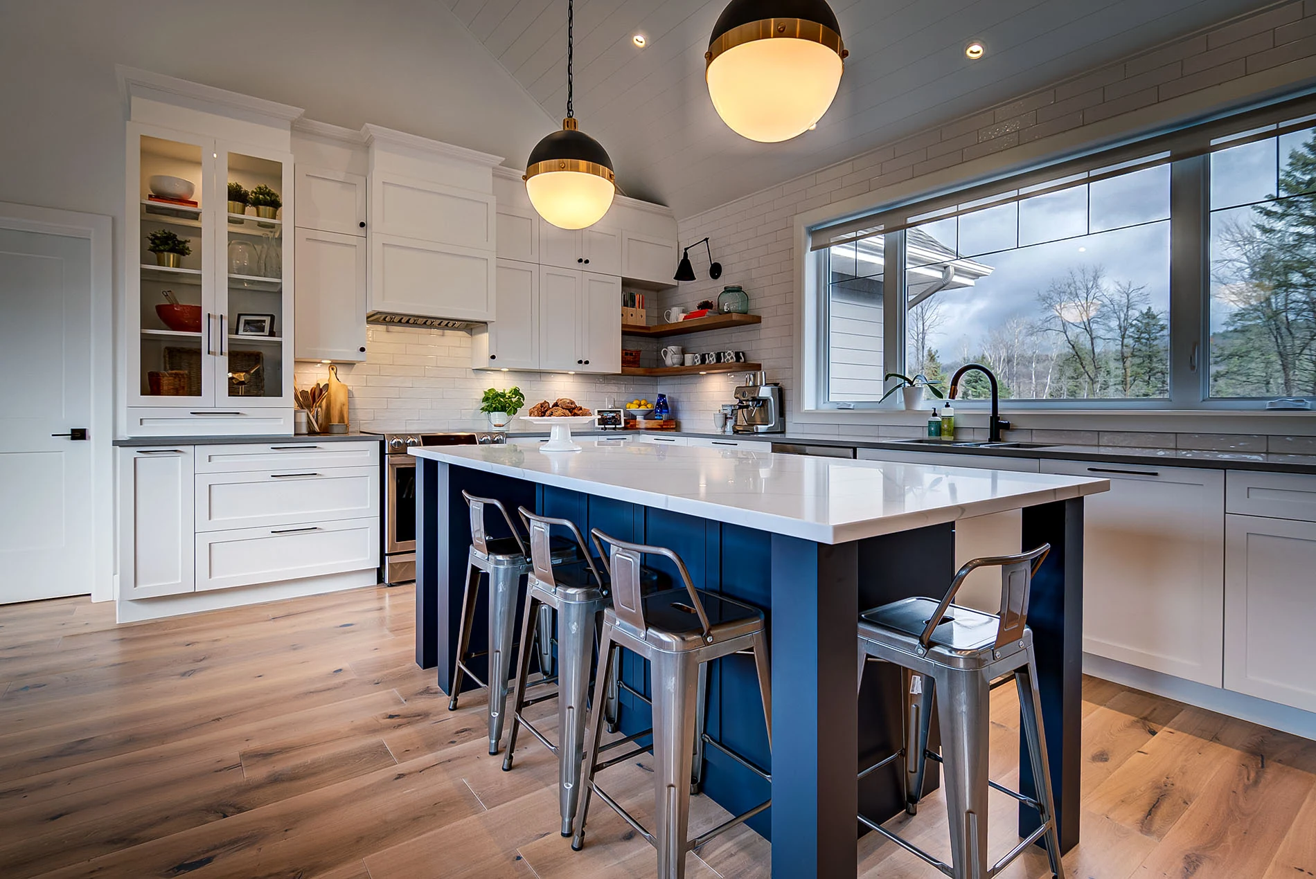 Cuisine blanche avec îlot bleu et places assises